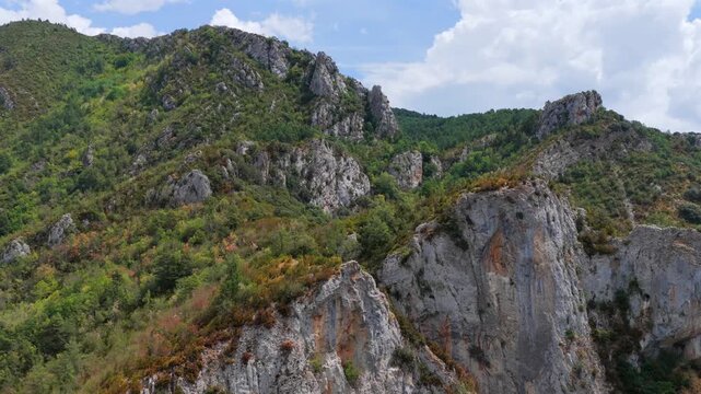 Aerial view of premature foliage yellowing and colorful dry mountain slopes due to severe heatwave near Ainsa, Pyrenees, Spain