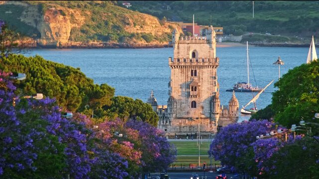 Jacaranda trees bloom near Belem Tower at sunset in Lisbon, Portugal