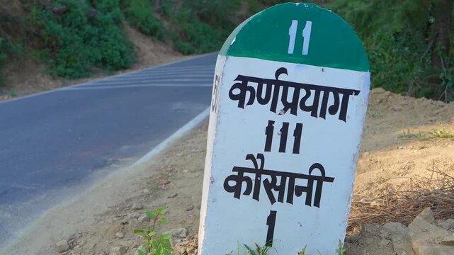 Hindi Road Milestone Showing Karnaprayag 111 km and Kausani 1 km, Uttarakhand