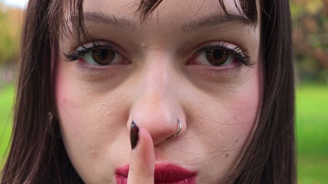 Close Up Portrait of Young Woman Making Shushing Gesture with Finger on Lips, Silent Sign for Quiet and Secrecy, Facial Expression, Secret Communication, Silence Concept and Nonverbal Body Language