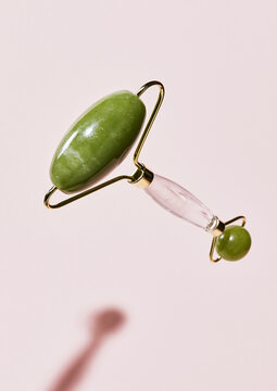 jade facial roller with crystal handle on pink
