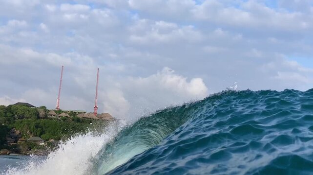 Inspiring cinematic view of breaking ocean barrel wave in vibrant turquoise sea water. Excellent background and intro scene for travel, adventure, and sports films