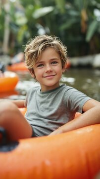 Young boy sitting on orange tube while leisurely drifting in pool
