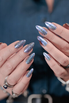 Female hand with long nails and bright light blue and silver manicure