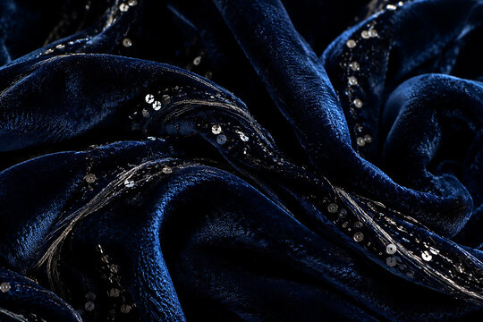 Elegant deep blue velvet fabric texture with silver sequin embroidery lines and luxurious drapes