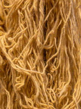 Detailed close-up texture of raw natural wool fibers and hand-spun yarn strands used in traditional Bedouin textile weaving.