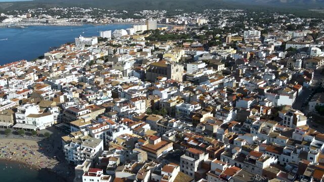 Wide aerial view of La Punta stone headland and L'Escala town overlooking the Mediterranean gulf. Panorama of Costa Brava, Girona, Catalonia, Spain