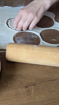 Woman hands making traditional pierogi dumplings at home kitchen table, rolling pin and raw dough preparing delicious homemade meal, authentic culinary workflow process for Polish cooking concept