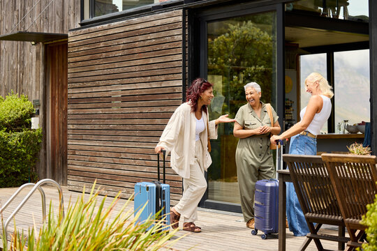 Friends chatting at the entrance of their rented vacation home.