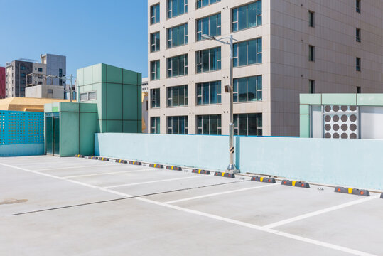Rooftop Parking Lot with Modern Buildings and Mint Structure