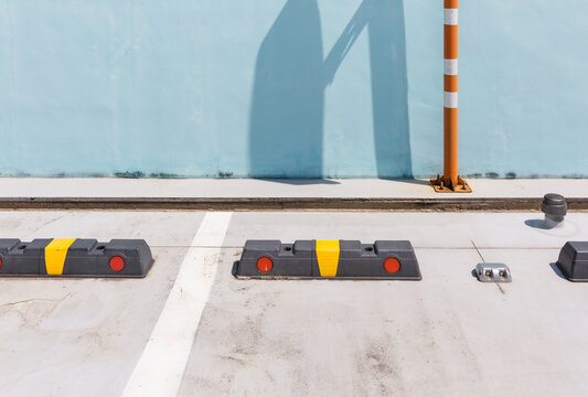 Rubber Wheel Stops in Parking Lot Against Blue Wall