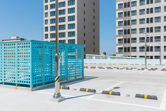 Rooftop Parking Lot with Blue Perforated Structure and High-Rises