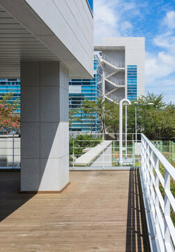 Modern Building Exterior View with Wooden Deck and Metal Staircase
