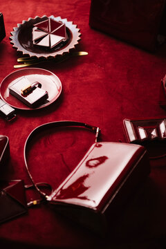 Red Leather Handbag And Accessories On Velvet