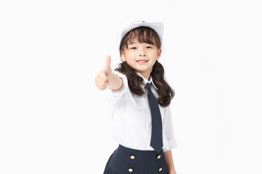 Smiling girl in sailor uniform giving thumbs up