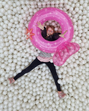 Happy girl in ball pit