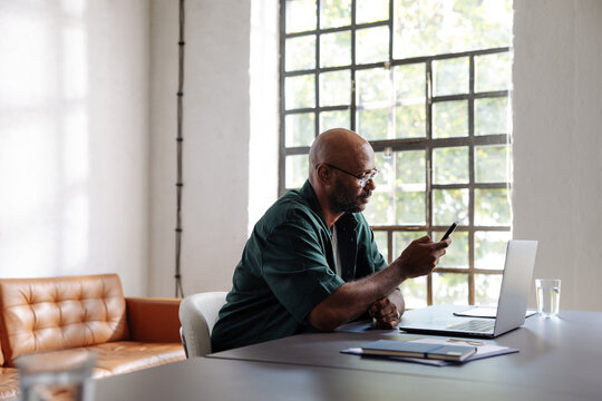 Businessman Working Remotely at Laptop and Phone