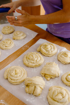 two neat rows of raw cinnamon rolls arranged on baking paper