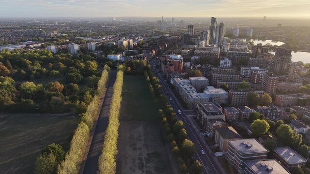 Aerial sunrise over Londons Finsbury Park and Seven Sisters Road, highlighting the West Reservoir in glowing morning light.