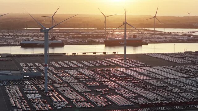 Aerial drone view of thousands of new import export cars parked in a sea port terminal. Commercial automotive supply chain and maritime freight logistics.