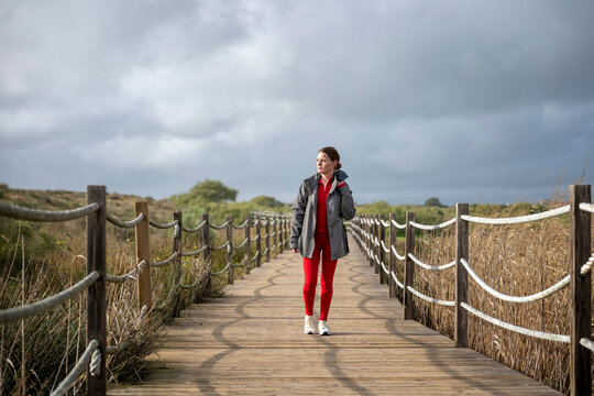Woman Walking Along a Coastal Boardwalk