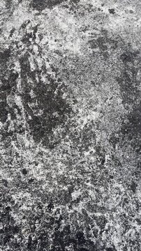 dirty concrete floor background, rough weathered surface with dark grunge stains in close-up, slow motion taken in 60fps