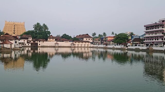 Flying Pigeons over Padma Theertham Tank Revealing the Distant Golden Gopuram of Sree Padmanabhaswamy Temple, Capturing the Sacred Reflection and Timeless Heritage of the World's Richest Hindu Shrine