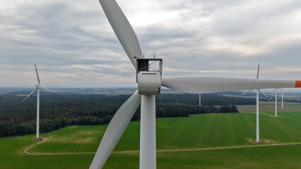 duże białe wiatraki elektrownie wiatrowe turbiny wiatrowe stojące na tle krajobrazu rolniczego © Adam Schmidt
