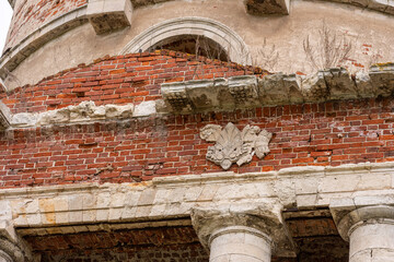 Close view of historic brick and stone masonry facade with arched window and carved ornament. Medieval architecture and heritage preservation. Historic building detail. © Natalia