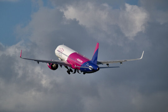 Rear view of Wizz Air Airbus A321 HA-LZK banking away in mid air against cloudy sky after takeoff, Gdansk, Poland, September 2026