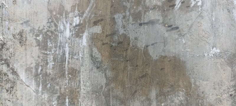 Raw concrete surface texture with dark moisture stains, weathered cement plaster, and rough rustic finish for urban backdrops, industrial covers, and grunge graphic design