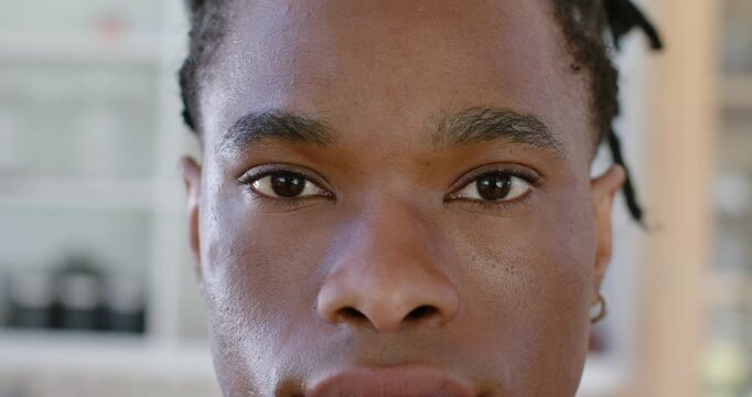 African American man opening eyelids from closed eyes in room showing hoop earring