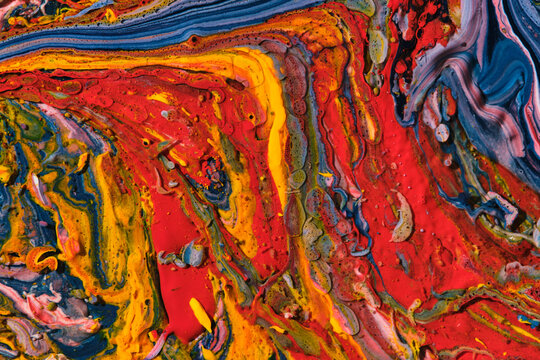 Vibrant abstract fluid art with mixed red, yellow and blue paint swirls and textures.