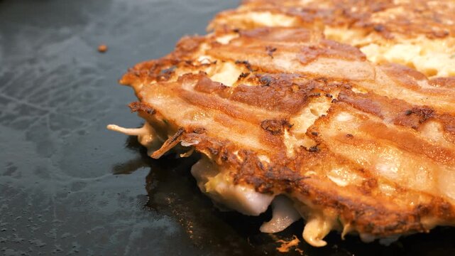 鉄板焼きミックス豚玉お好み焼き香ばしい焼き目クローズアップ
