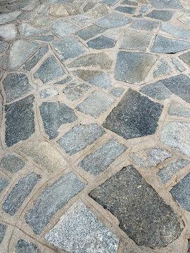 High-angle background view of  outdoor patio floor made of irregular natural stone flags, ideal as graphic resource and seamless abstract texture for architectural projects.