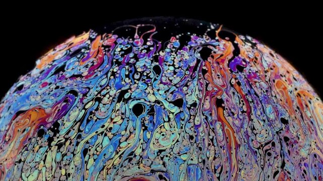 Soap bubble starting to loose cohesion as fragmentation shows up and really thin black of film layer going up and accumulation at the top of the bubble.