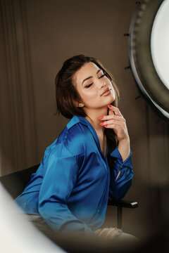 Professional lighting illuminates a stylish female model posing with confidence during a commercial photoshoot.