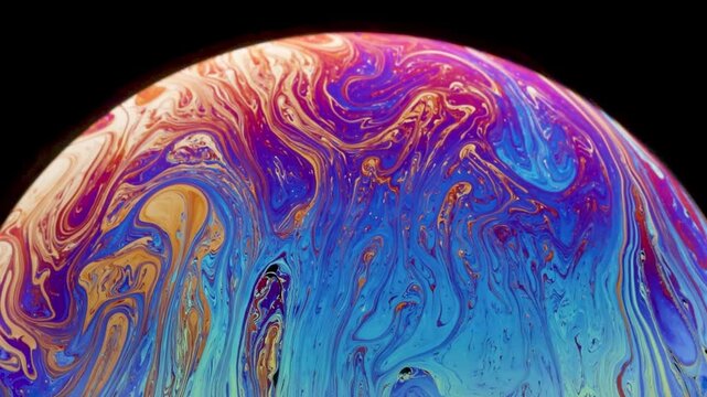 Soap bubble starting to loose cohesion as fragmentation shows up and really thin black of film layer going up and accumulation at the top of the bubble.