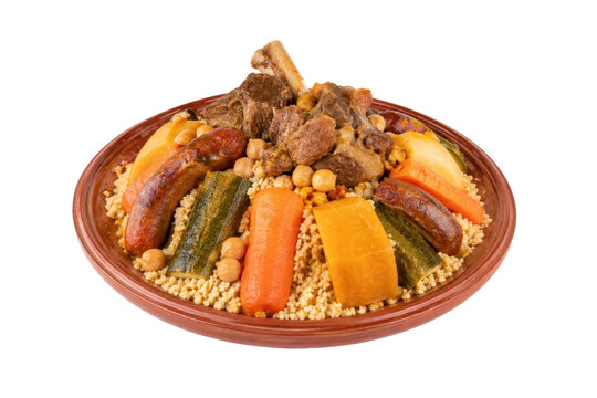 Traditional Moroccan couscous dish with tender lamb, merguez sausage, chickpeas, and various steamed vegetables served on a rustic clay plate
