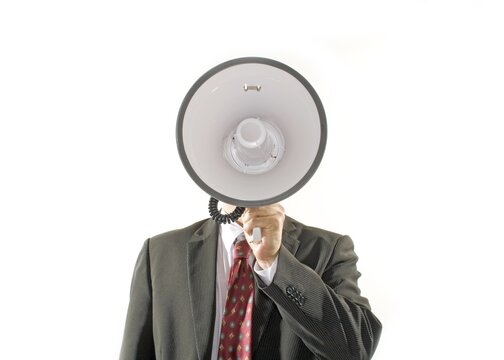 Business man screaming into a megaphone