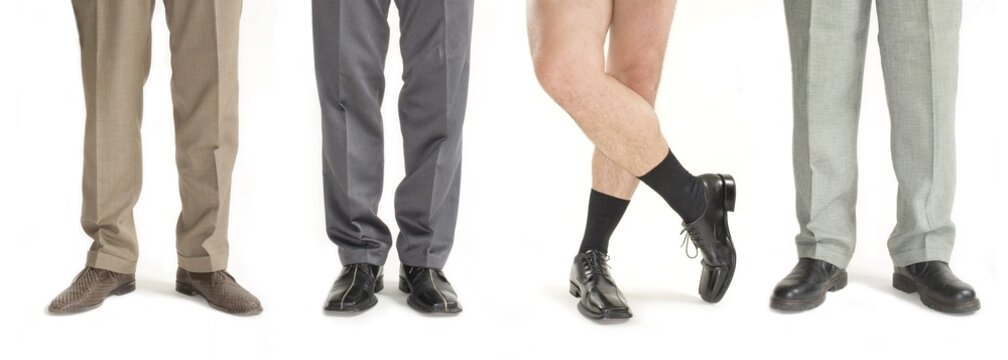 Four businessmen standing in a row, one without pants, detail of legs