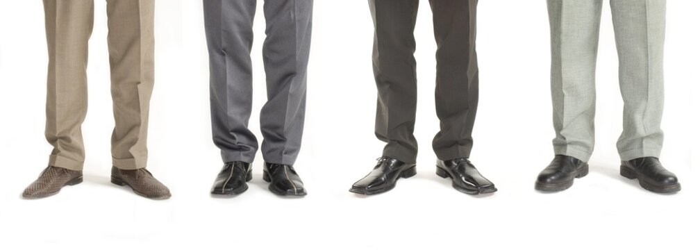 Four businessmen standing in a row, detail of legs