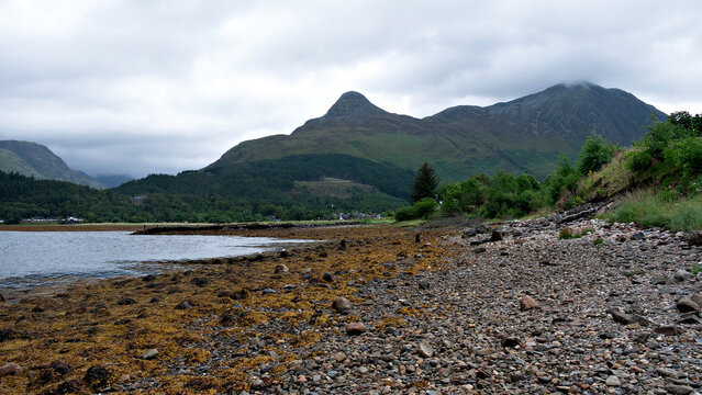 Loch Leven, pointy Sgorr na Ciche, (the Pap of Glencoe) and Sgorr nam Fiannaidh above Glencoe village, Lochaber, Scottish highlands.