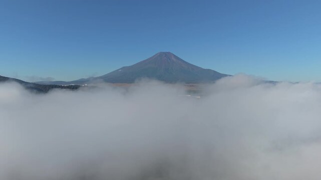 雲海の上を富士山に向かって飛行するドローンの等倍速映像（ドリーイン・前進）