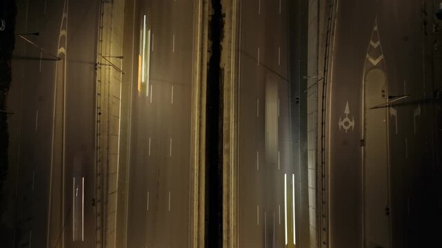 Aerial night timelapse of tow truck loading disabled vehicle to flatbed on multi-lane road