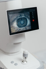Dry eye analyzer screen with close-up of human eye and Placido rings on cornea, joystick control in ophthalmology clinic. Tear film test, eye care and vision diagnostics concept © Valeriia Stoganenko