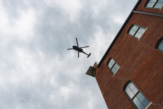 Military escort helicopters flying over brick buildings in Jefferson City, Missouri, July 2026