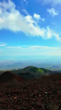 Aerial drone footage of red volcanic gravel slope on Mount Etna with valley view in Sicily Italy