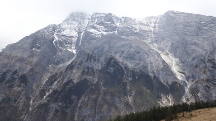 Snow streaks on rocky cliffs of Jade Dragon Snow Mountain in China © Zeyu