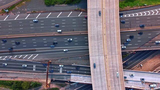 Concrete overpass above the numerous multi-lane highway. Top view on the road with hectic traffic at daytime.